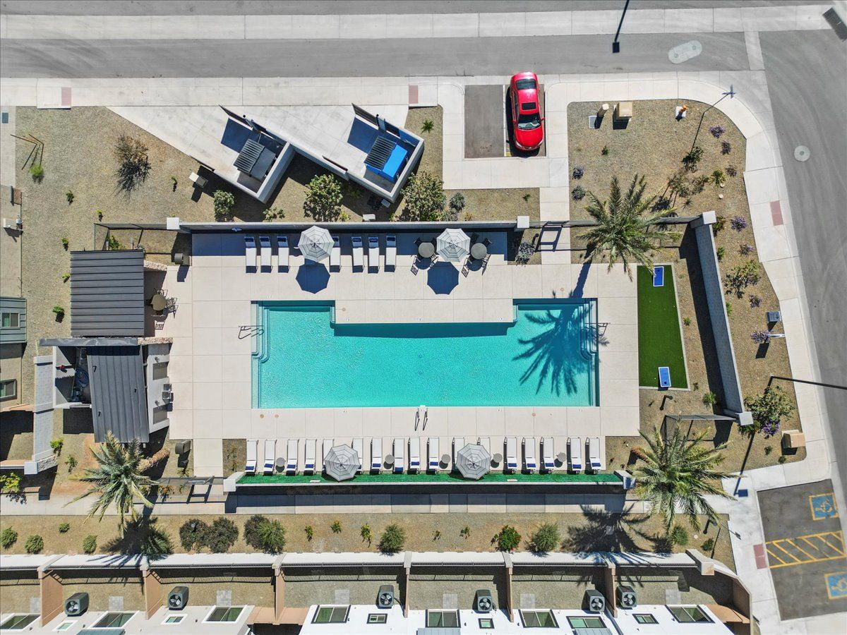 An aerial view of a swimming pool surrounded by palm trees
