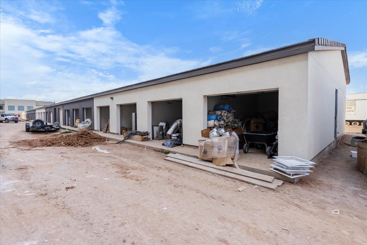 A building under construction with a lot of trash in front of it.