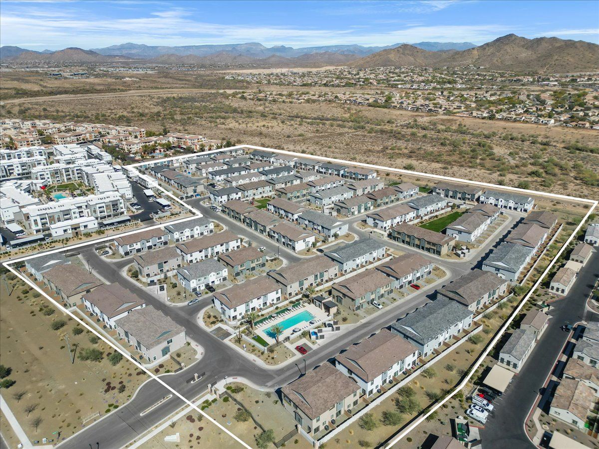 An aerial view of a residential area with mountains in the background.