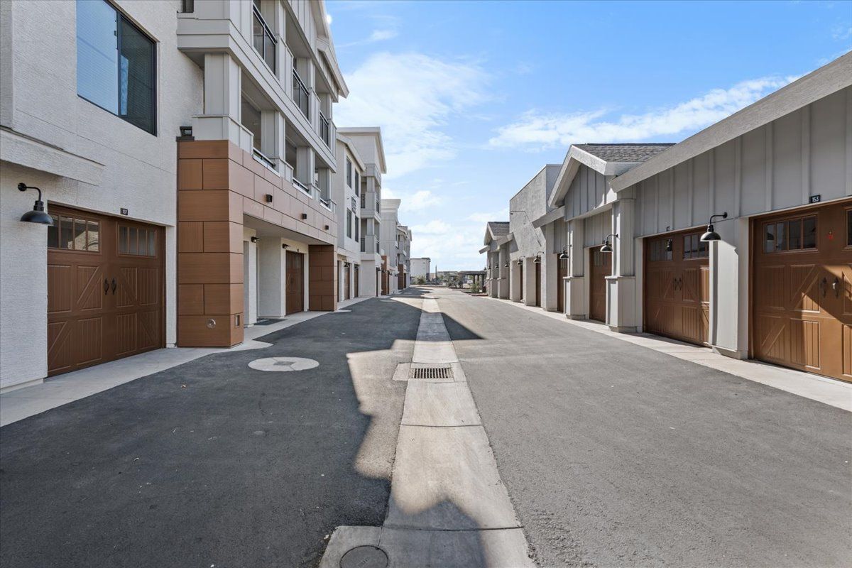 A row of buildings with garages on the side of the road.