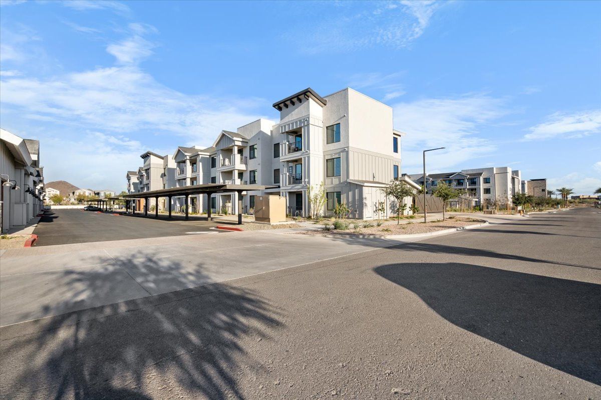 A large apartment building with a parking lot in front of it.