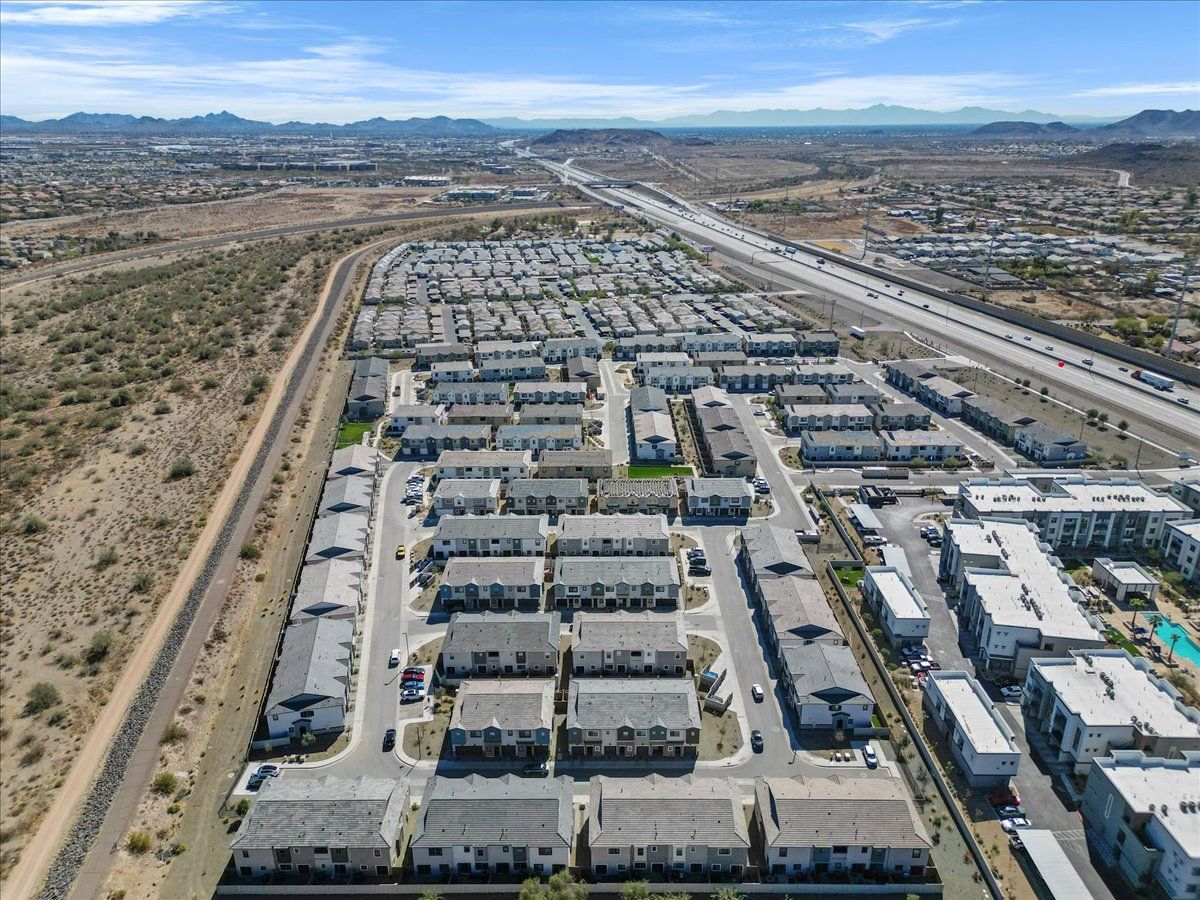 An aerial view of a residential area with a highway in the background.