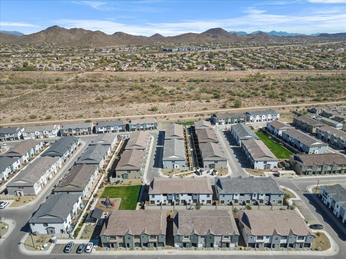 An aerial view of a residential area with mountains in the background