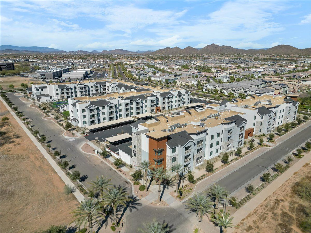 An aerial view of a residential area with lots of buildings and palm trees.