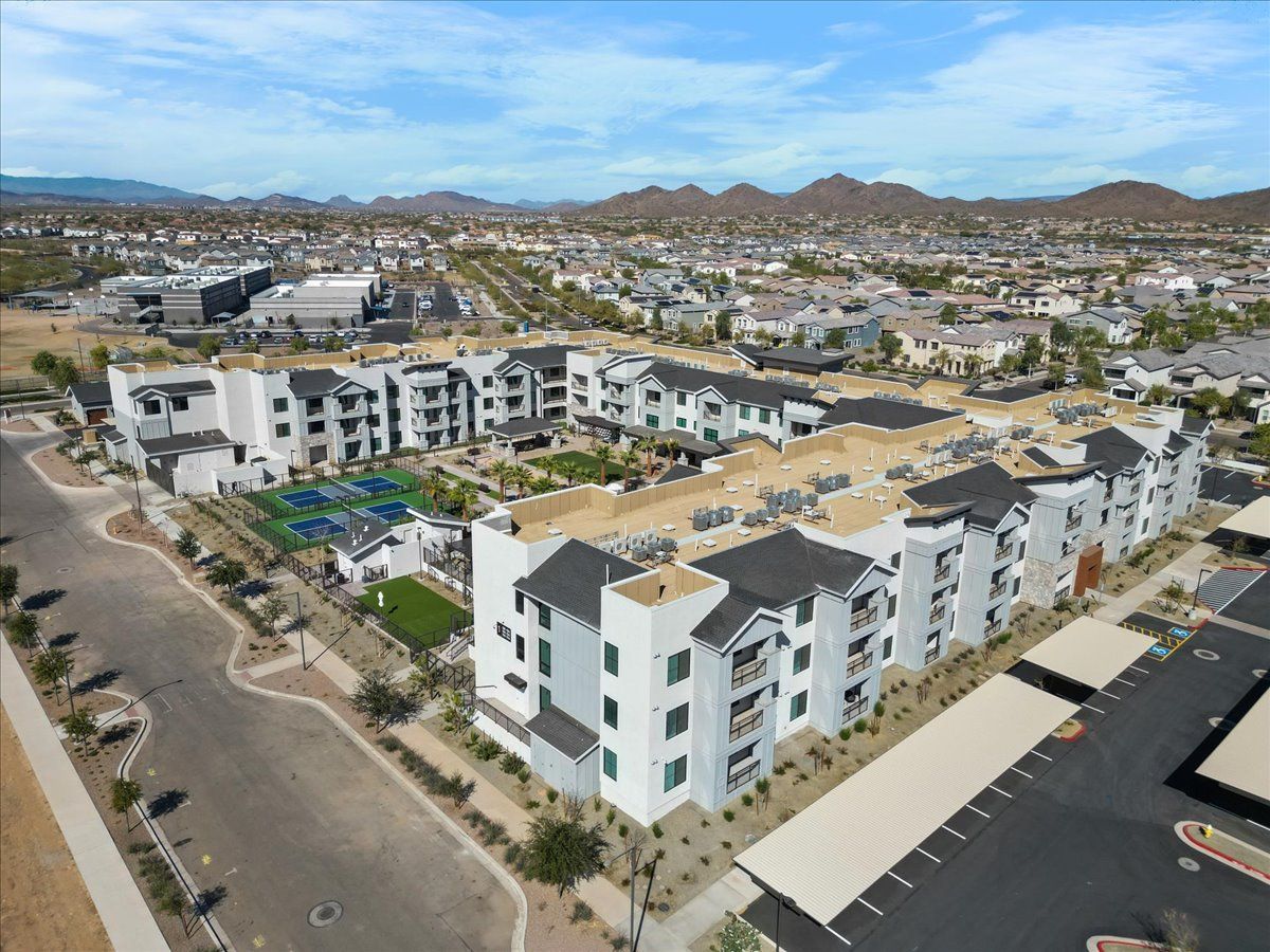 An aerial view of a large apartment complex with mountains in the background.