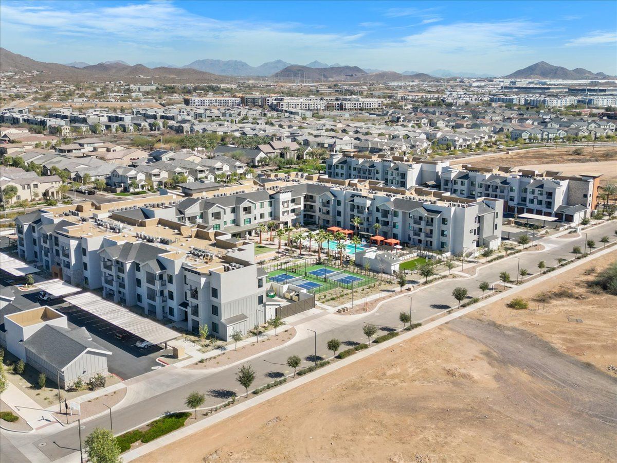 An aerial view of a residential area with a lot of buildings and a pool.