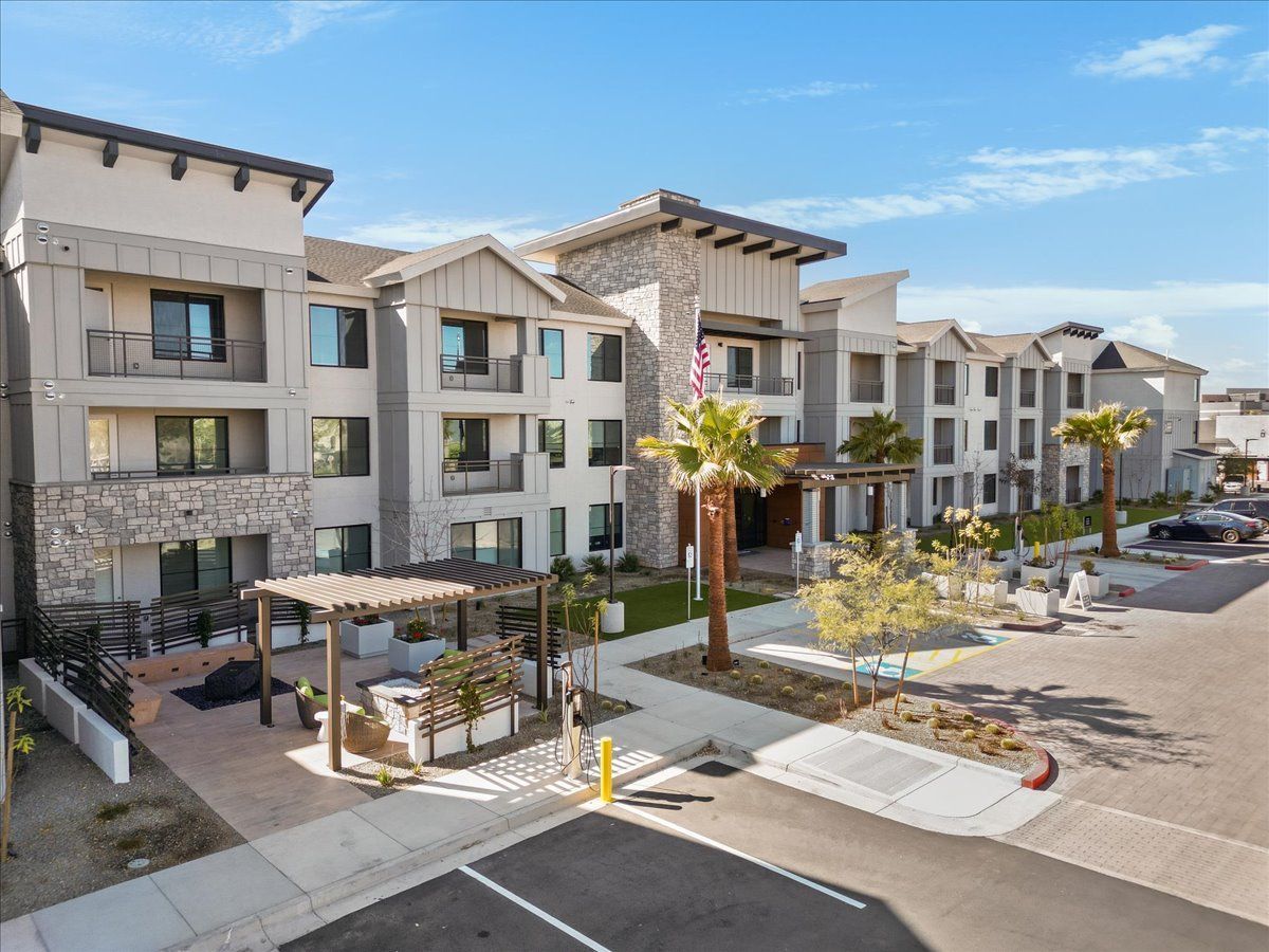 An aerial view of a large apartment building with a parking lot in front of it.