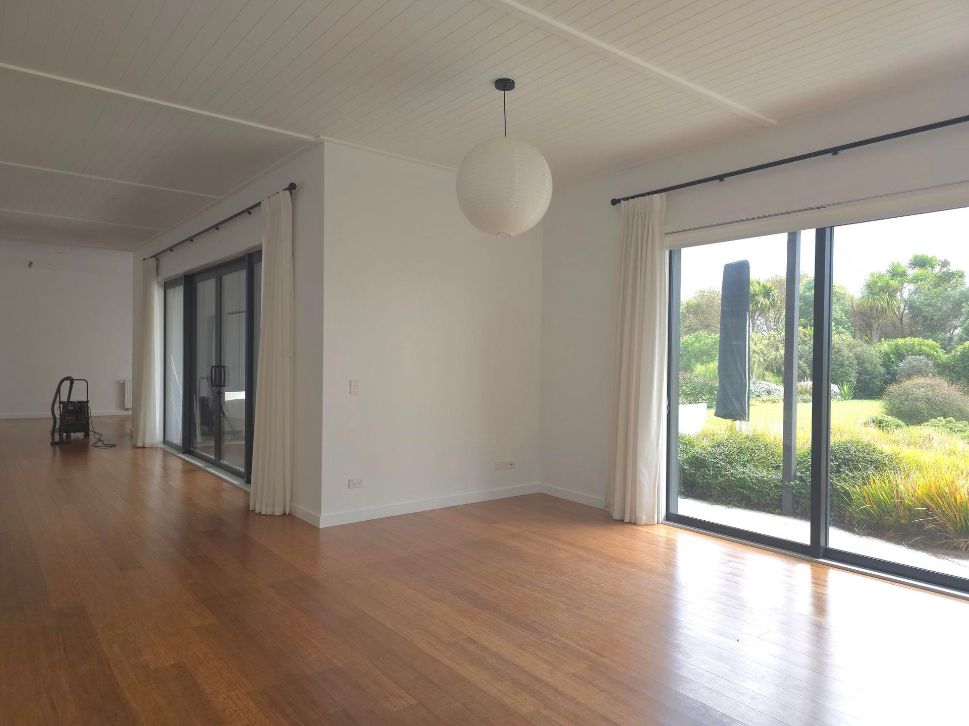 Man painting a wall teal with a roller in a room under renovation.