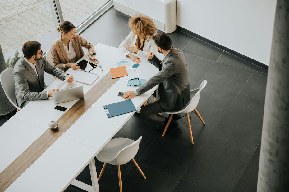 A group of business people are sitting around a table having a meeting.
