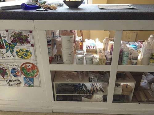 Counter with display of products, art on side, and objects on top.