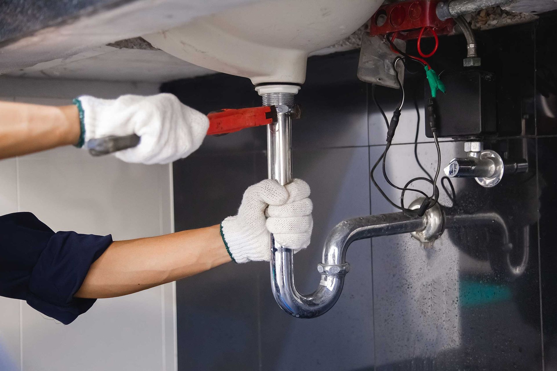 Plumber Fixing White Sink Pipe — Sarasota, FL — Strode Plumbing