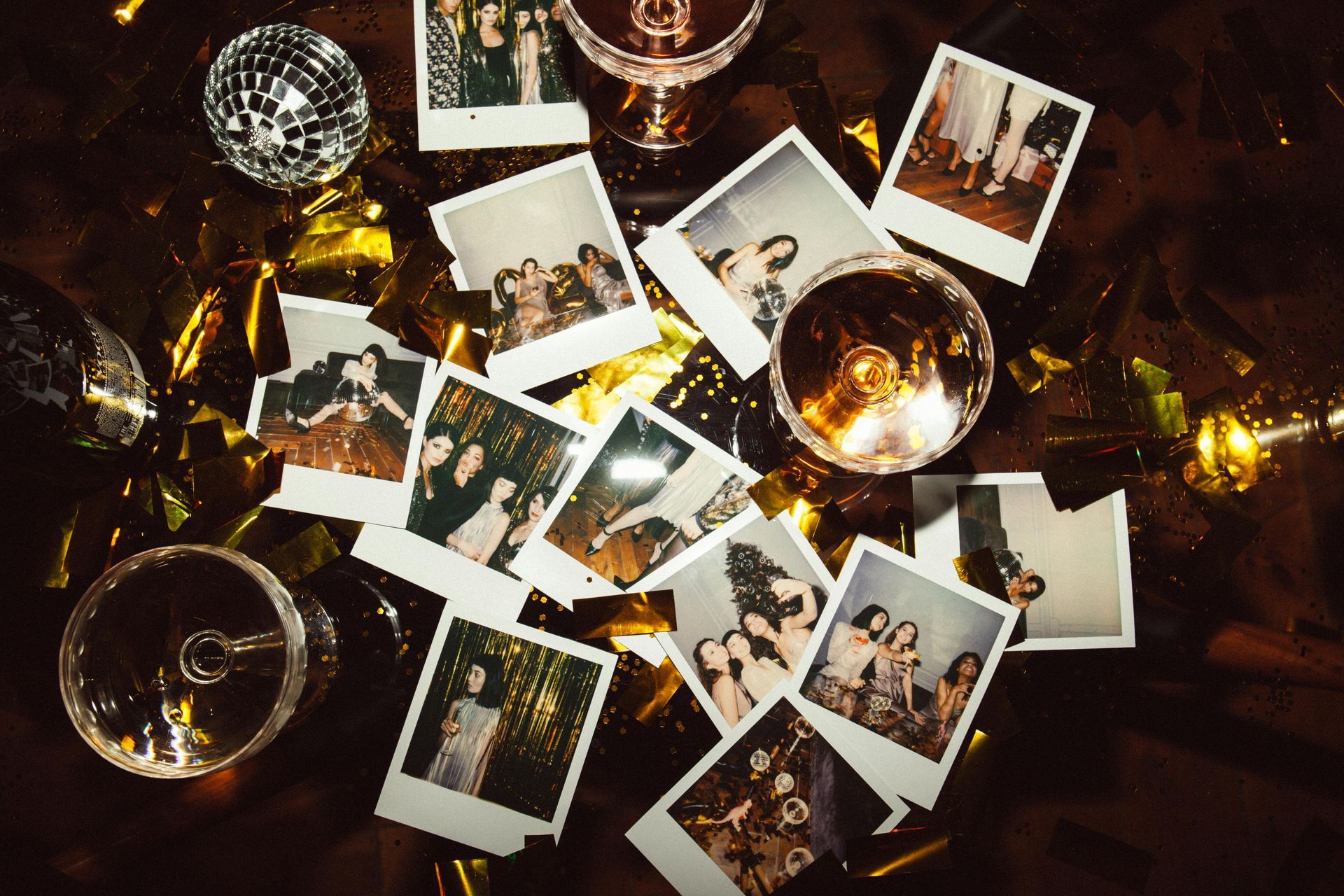 Des photos Polaroid parsemées de boules disco et de confettis dorés ; des coupes de champagne trônent à l'arrière-plan.