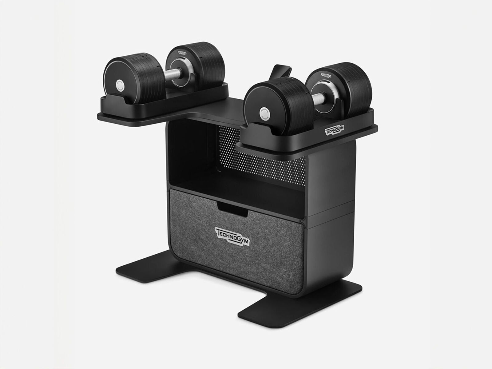 Black Technogym adjustable dumbbell rack with two dumbbells resting on top and a storage drawer below.