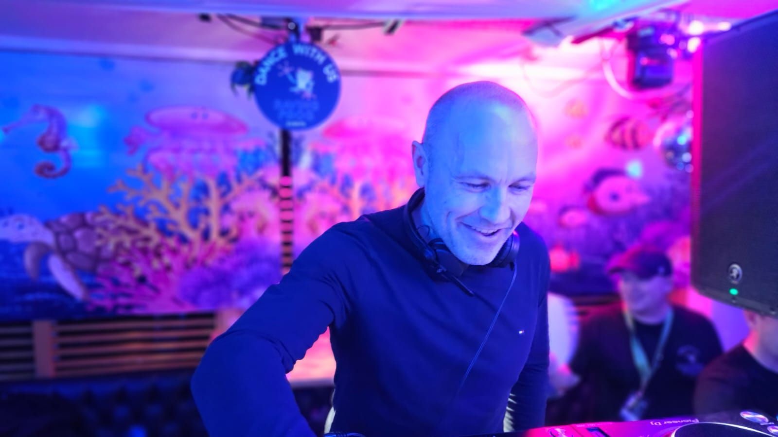 A man wearing headphones is playing music at a party.