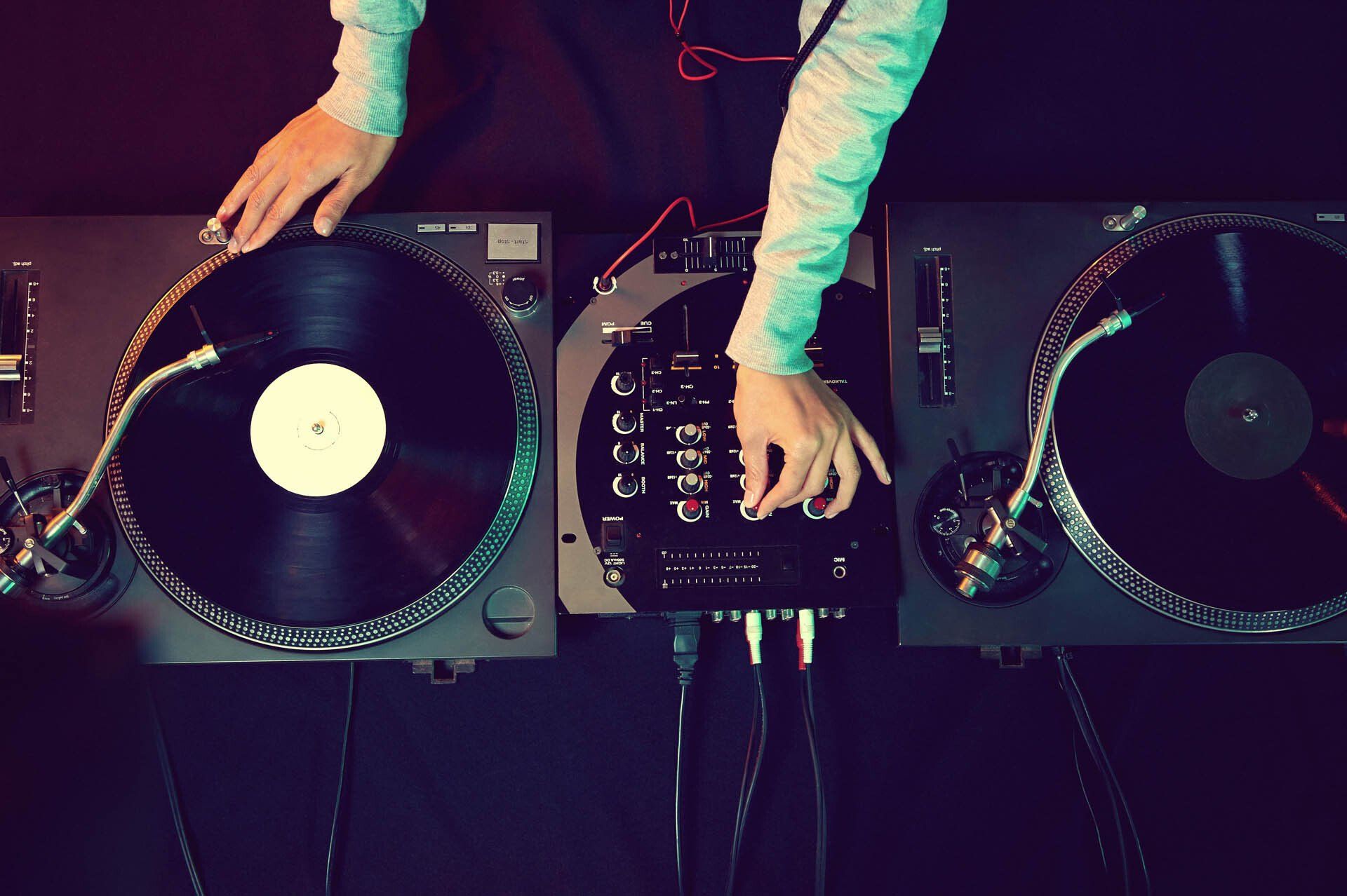 A dj is playing records on two turntables.