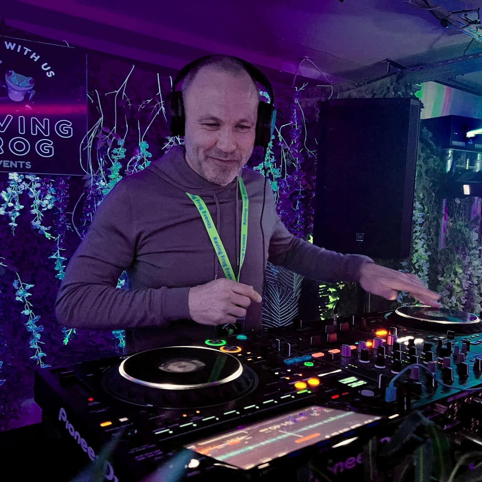 A man wearing headphones is playing music on a turntable.