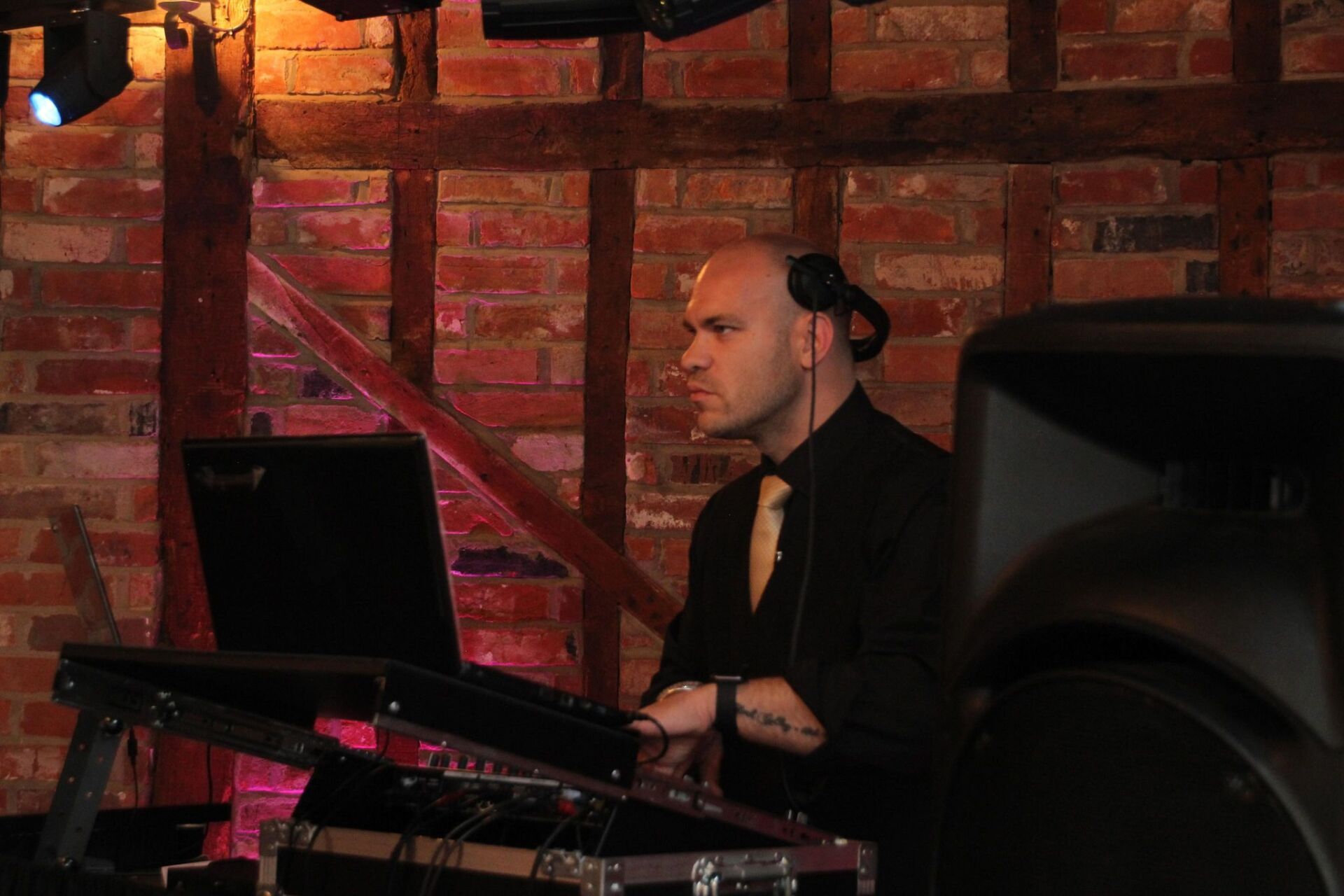 A man in a suit and tie is playing music on a laptop.