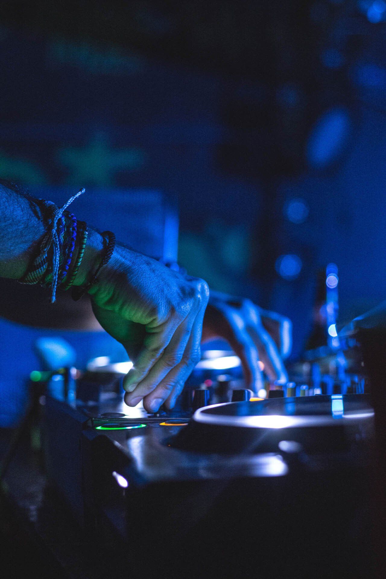 A dj is playing music on a turntable in a dark room.