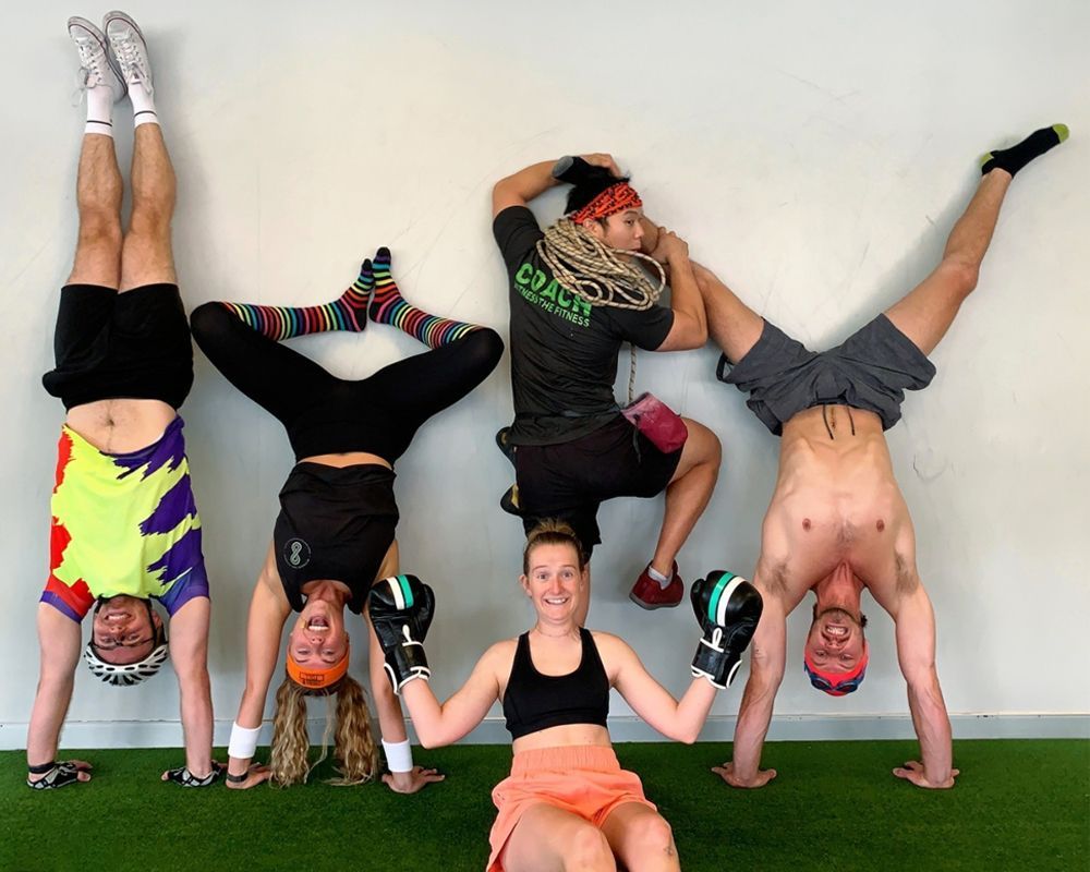 A group of people doing handstands and boxing gloves