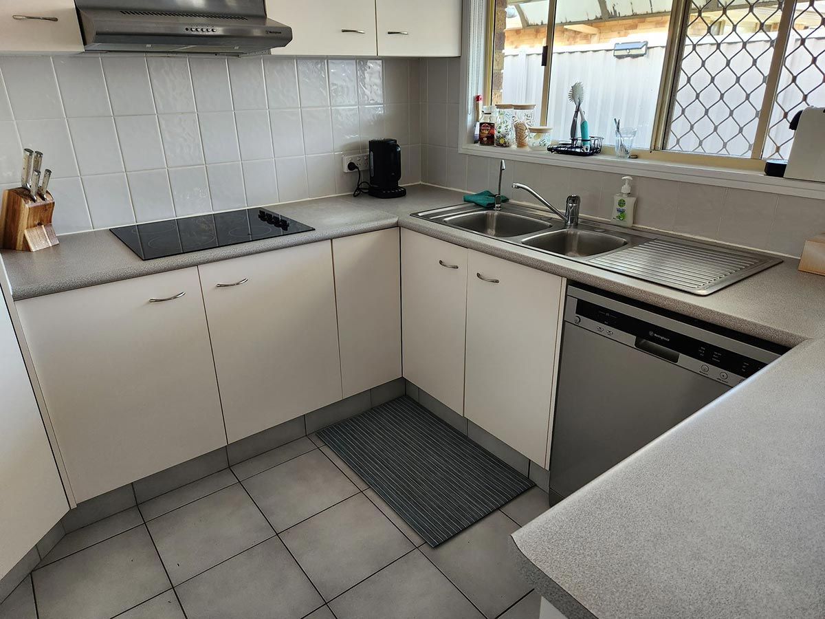 L-Shaped Kitchen with White Cabinets, Light Gray Countertops — KirraLina Cleaning Services in Tweed Heads, NSW