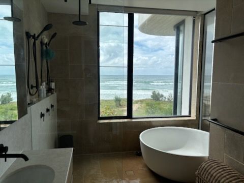 A Modern Bathroom with A Large Window Overlooking the Ocean — KirraLina Cleaning Services in Tweed Heads, NSW