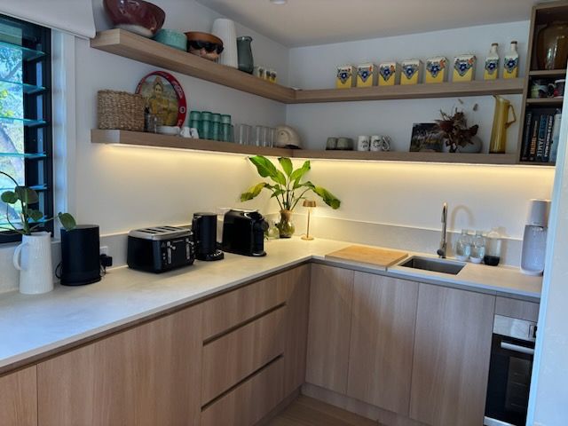 Cozy Kitchen Corner with Light Wood Cabinets, Countertops, and Floating Shelves — KirraLina Cleaning Services in Tweed Heads, NSW