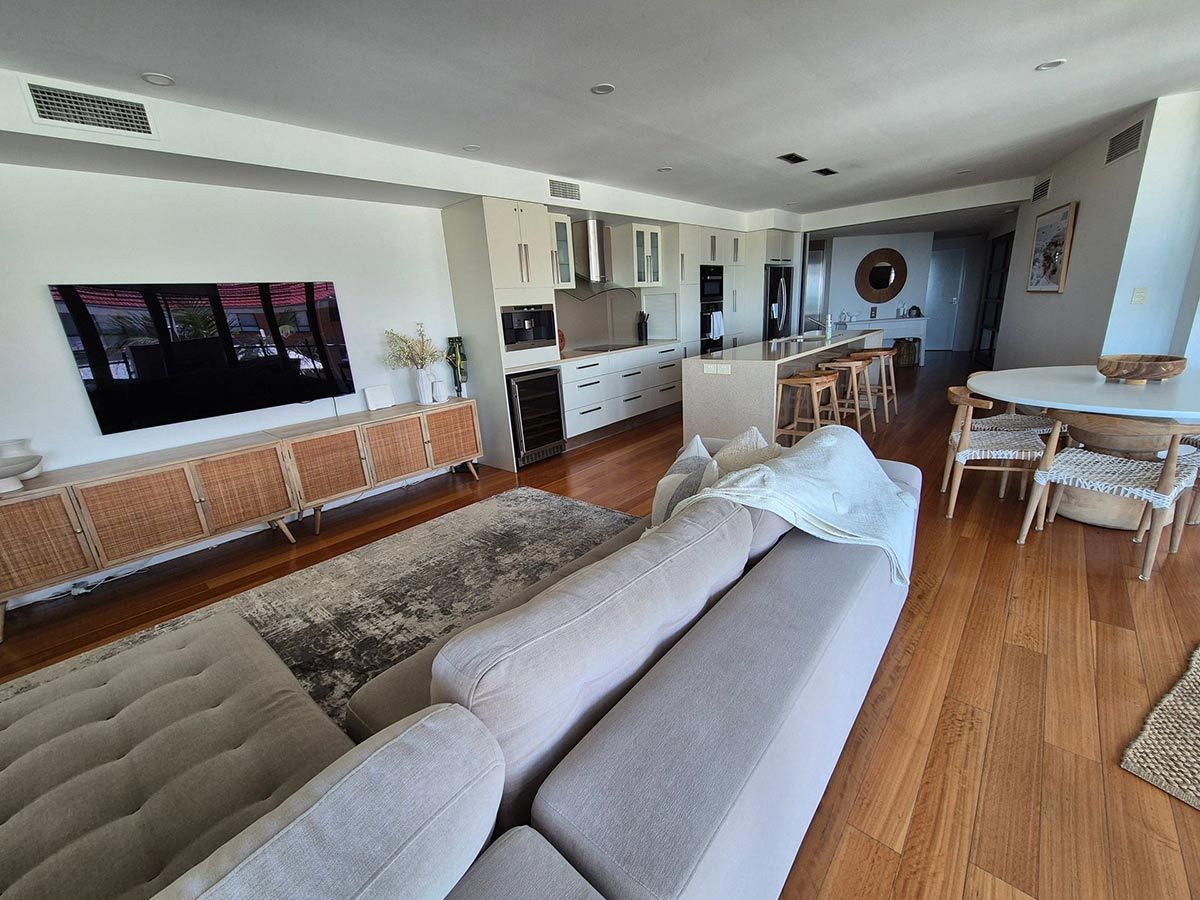 A Modern, Well-Lit Living Space with A Sectional Sofa, Kitchen Island — KirraLina Cleaning Services in Tweed Heads, NSW