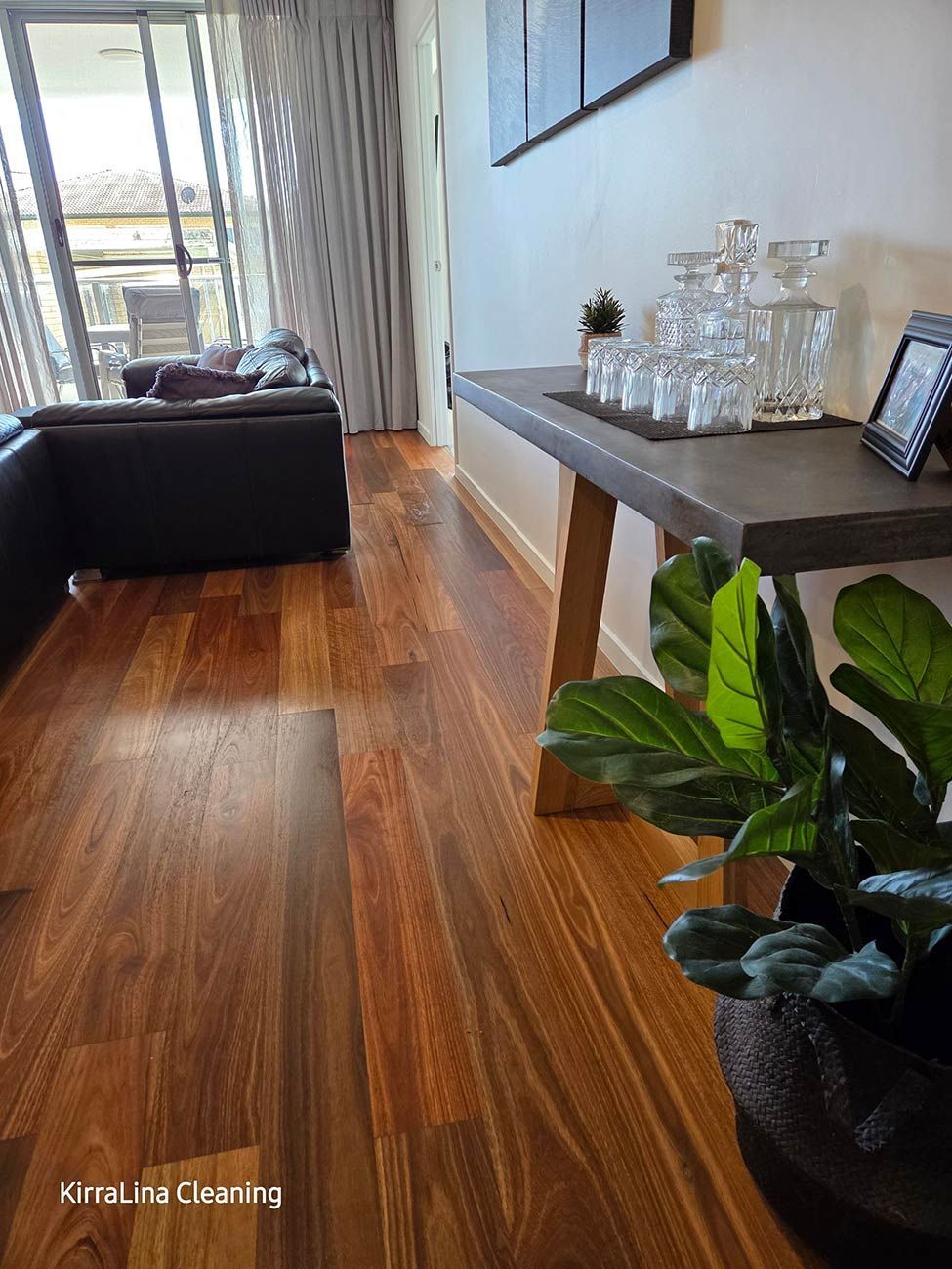Wooden Floors in A Living Room with A Black Leather Sofa — KirraLina Cleaning Services in Tweed Heads, NSW