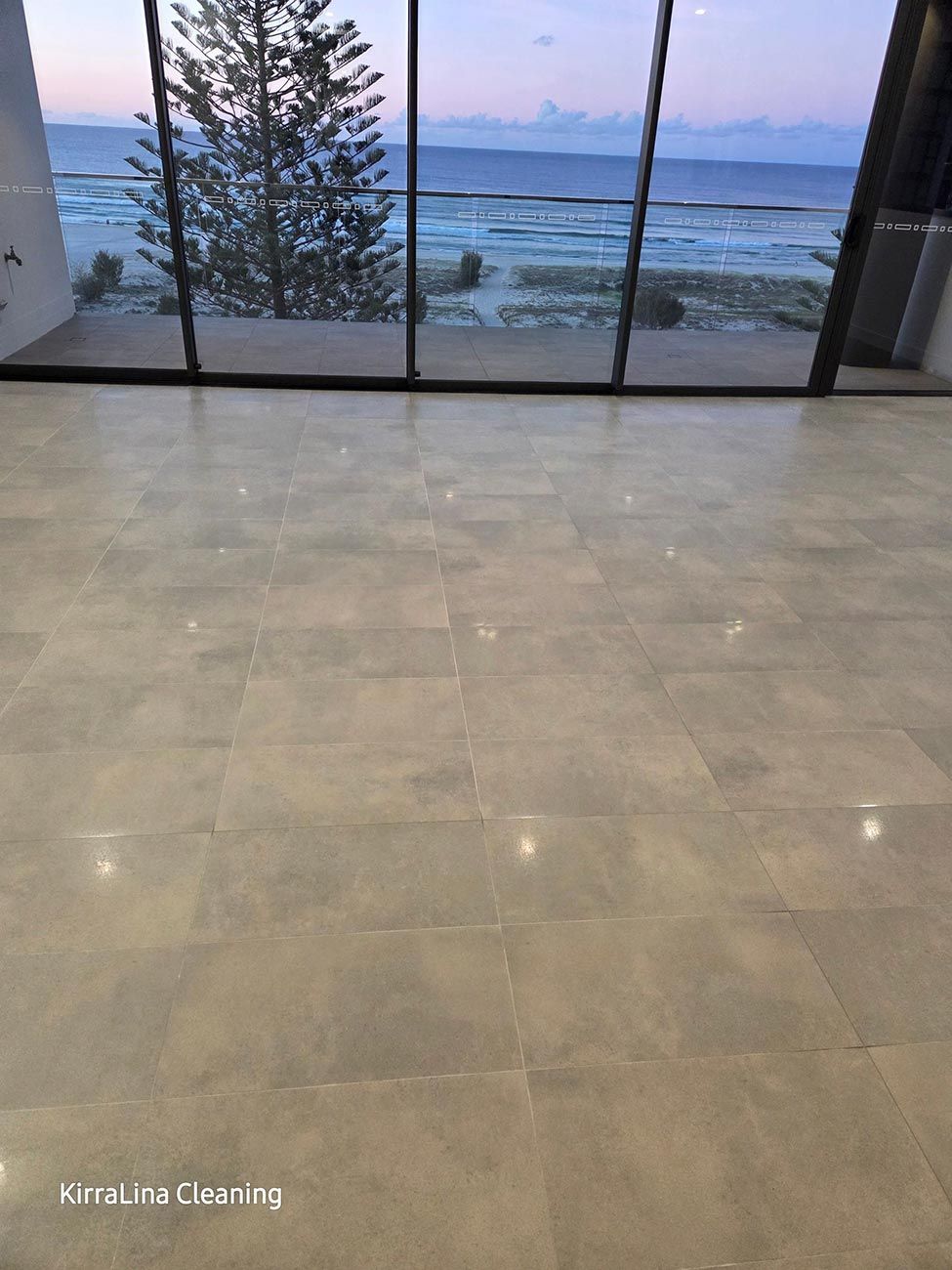 Empty Room with Large Windows Overlooking a Body of Water. Gray Tile Floor — KirraLina Cleaning Services in Tweed Heads, NSW