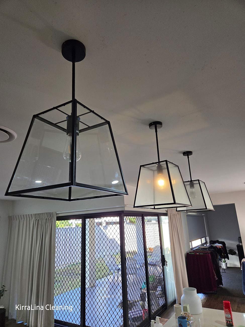 Three Black Framed Pendant Lights Hanging from A White Ceiling — KirraLina Cleaning Services in Tweed Heads, NSW