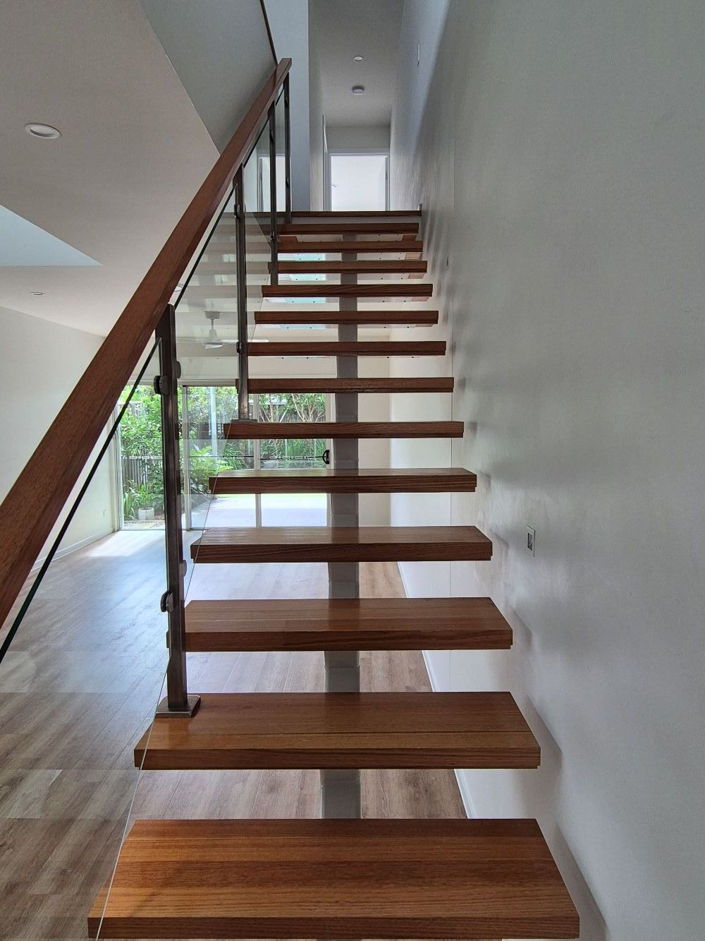 A Wooden Staircase with A Glass Railing — KirraLina Cleaning Services in Kingscliff, NSW