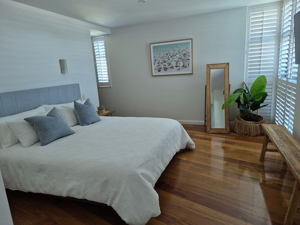 Bedroom with A Large Bed, Light Blue Pillows — KirraLina Cleaning Services in Tweed Heads, NSW