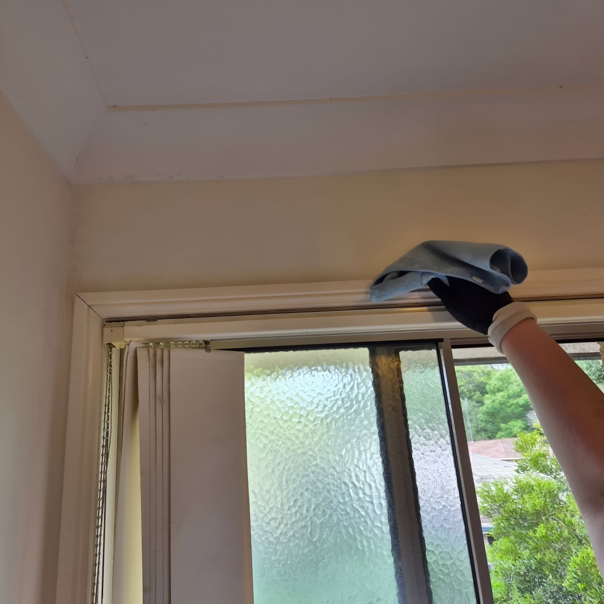 A Person Is Cleaning a Window with A Cloth — KirraLina Cleaning Services in Tweed Heads, NSW