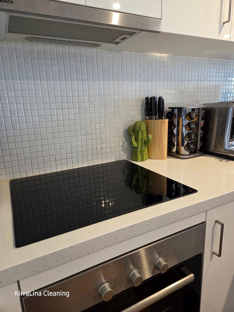 Kitchen with Black Stovetop, Stainless Steel Oven, and White Countertops — KirraLina Cleaning Services in Tweed Heads, NSW