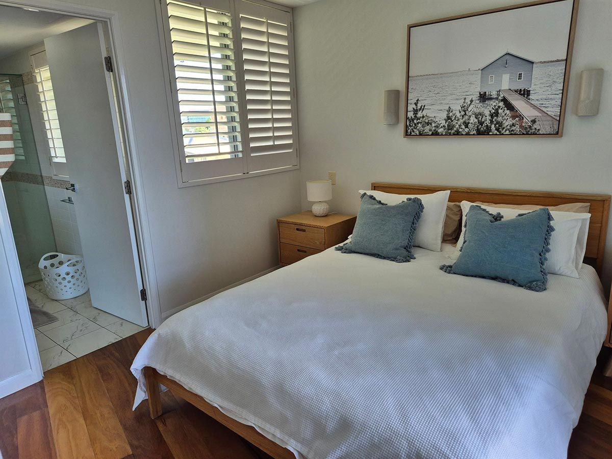 Bedroom with A Double Bed, Light Wooden Floors, and A Bathroom Entrance — KirraLina Cleaning Services in Tweed Heads, NSW