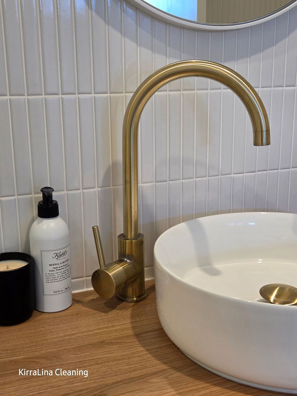 Gold Faucet Over a White, Round Sink on A Wooden Countertop — KirraLina Cleaning Services in Tweed Heads, NSW