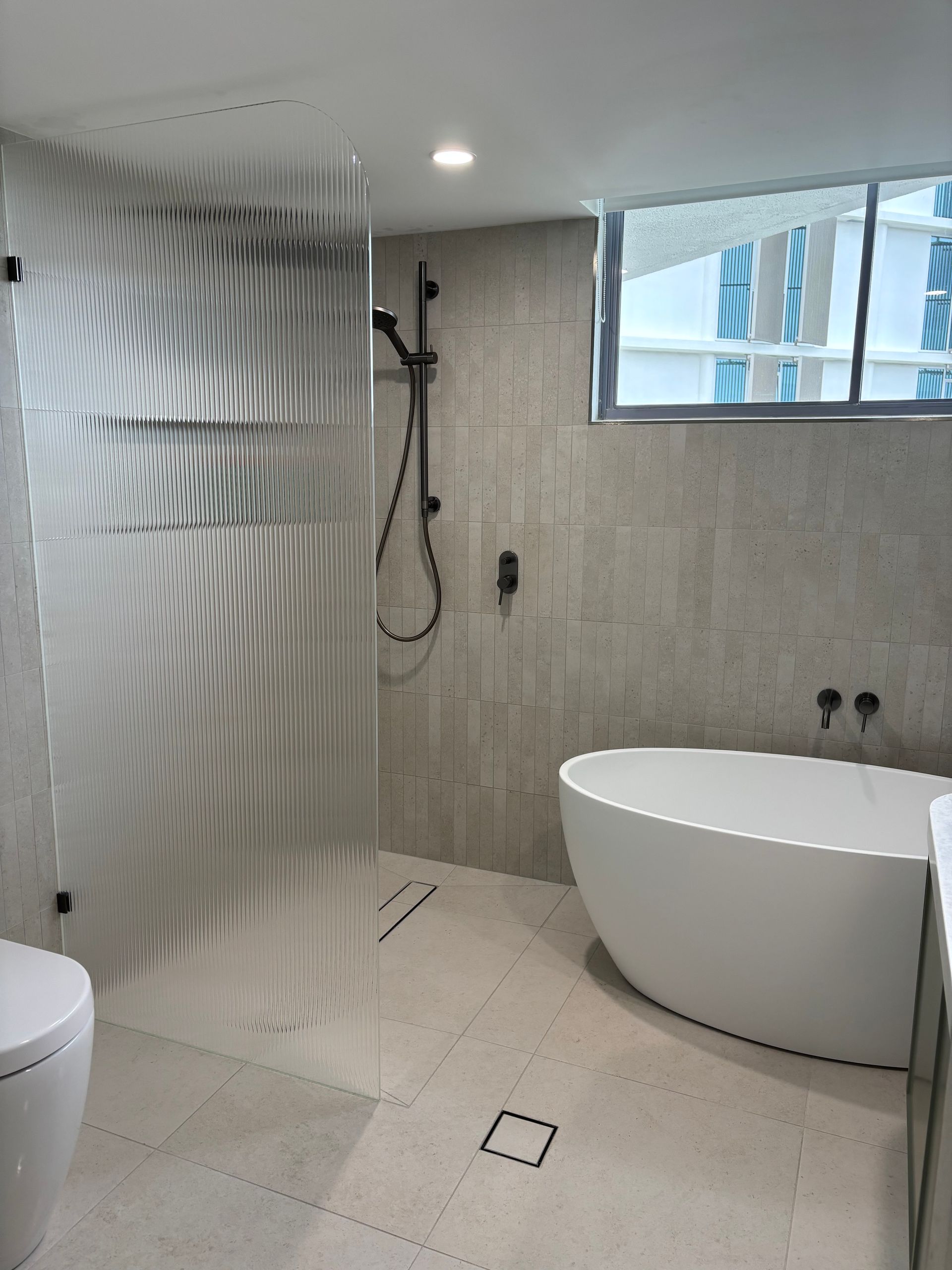 Modern Bathroom with Glass Shower and white porcelain bathtub — KirraLina Cleaning Services in Tweed Heads, NSW