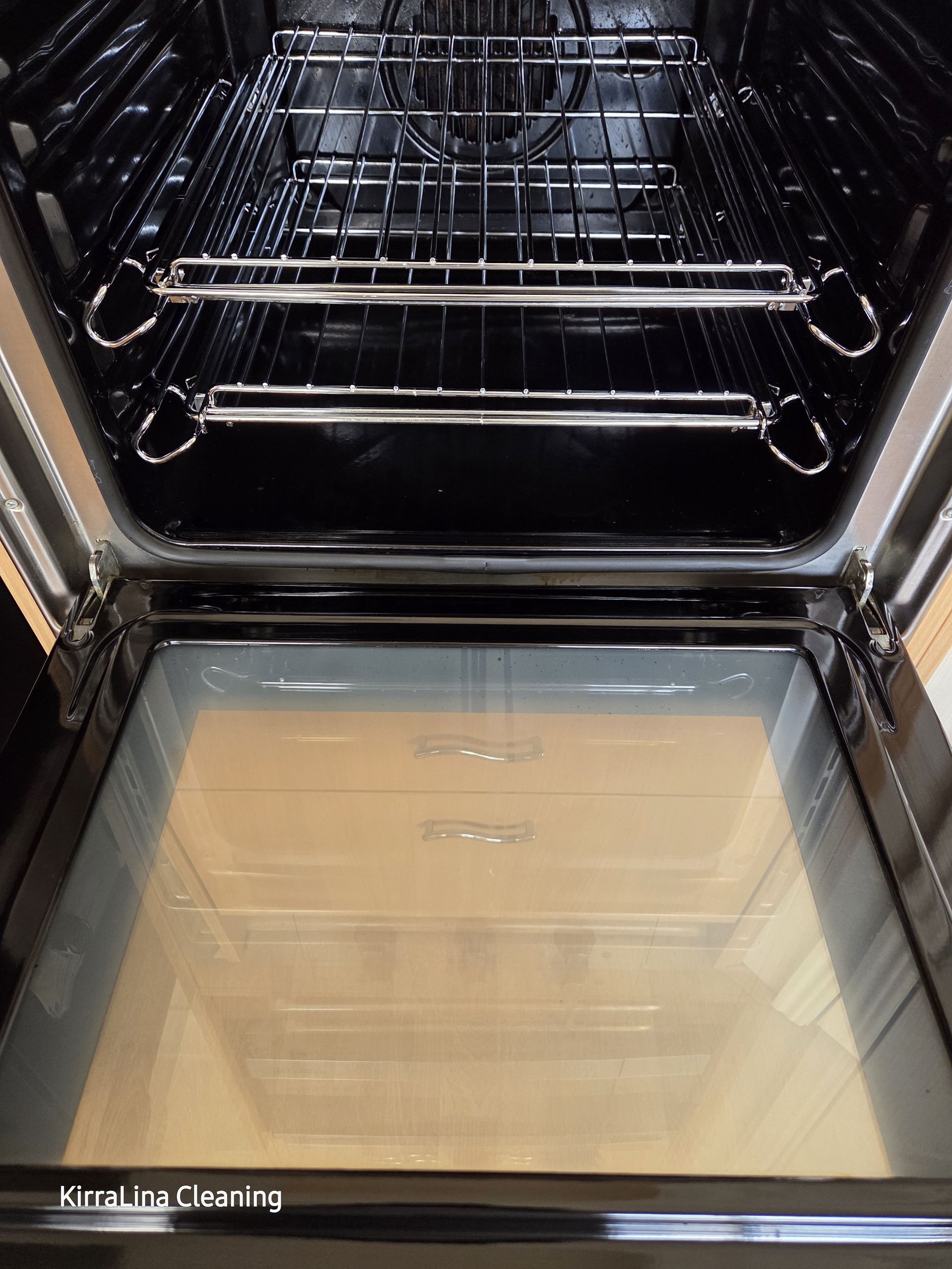 Open oven with wire racks and a glass door, showing the interior and empty baking trays. — KirraLina Cleaning Services in Tweed Heads, NSW