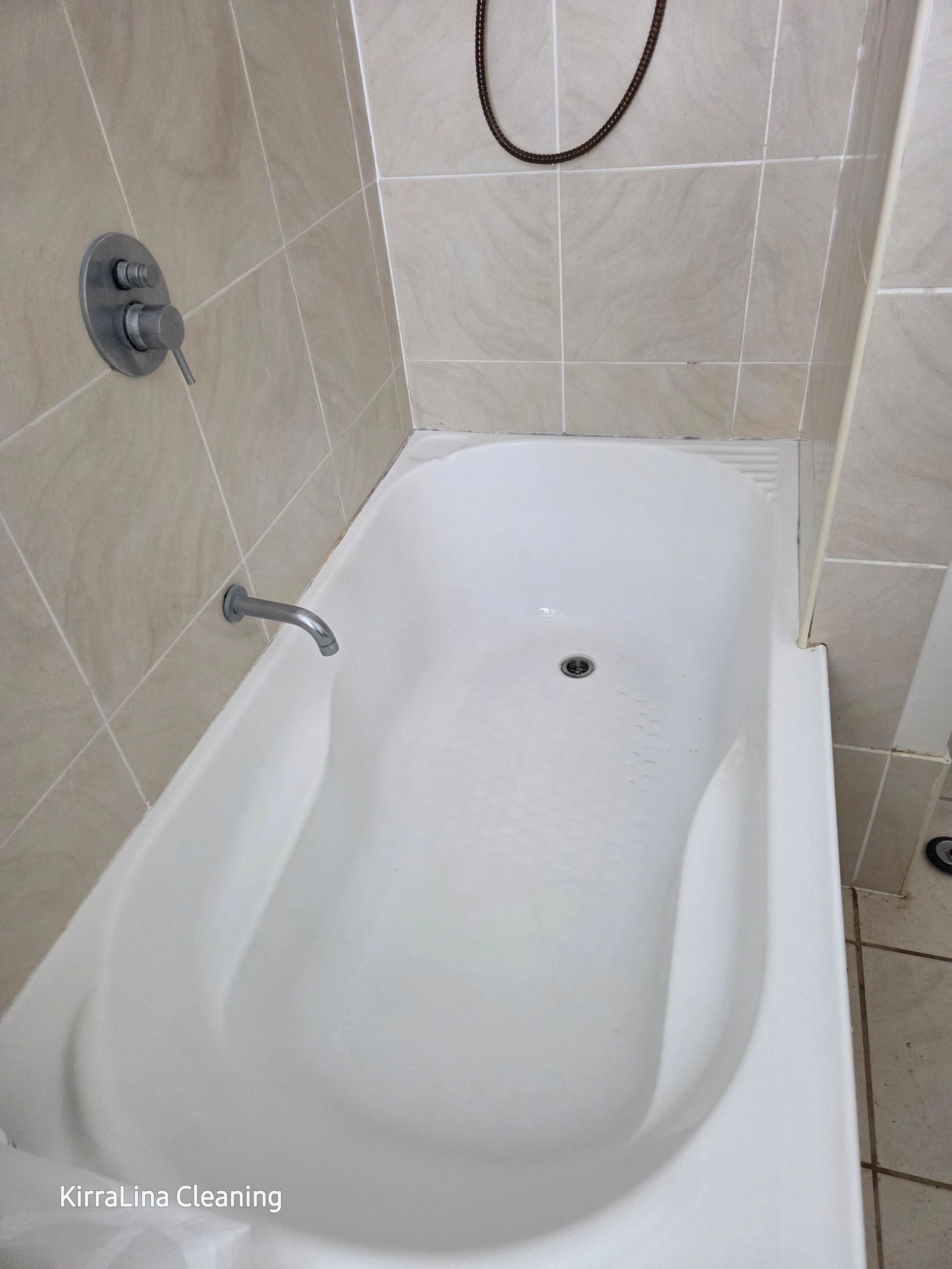White bathtub in a tiled bathroom, with chrome faucet and showerhead — KirraLina Cleaning Services in Tweed Heads, NSW
