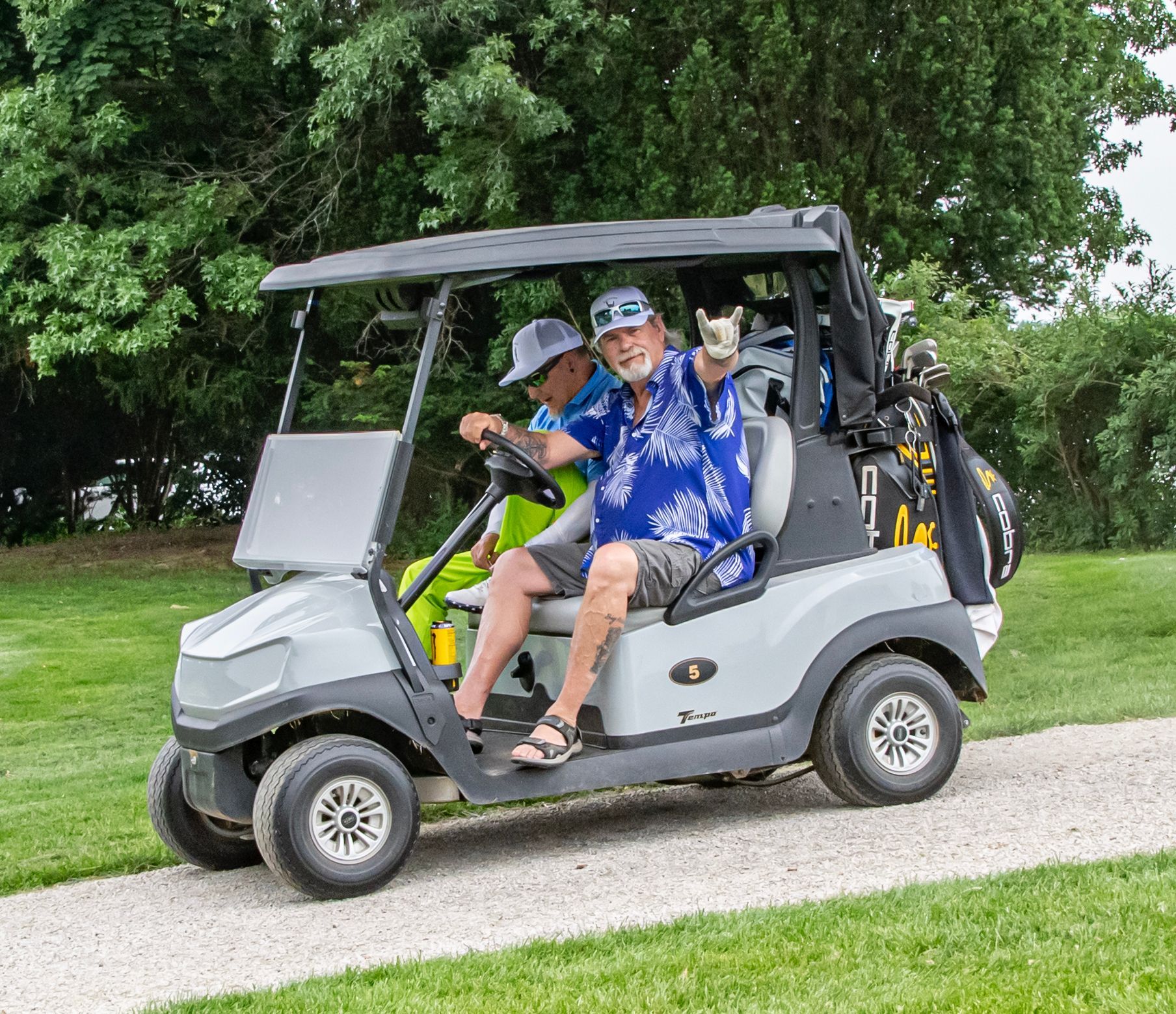 golfers riding a golf cart on their way to the next hole.