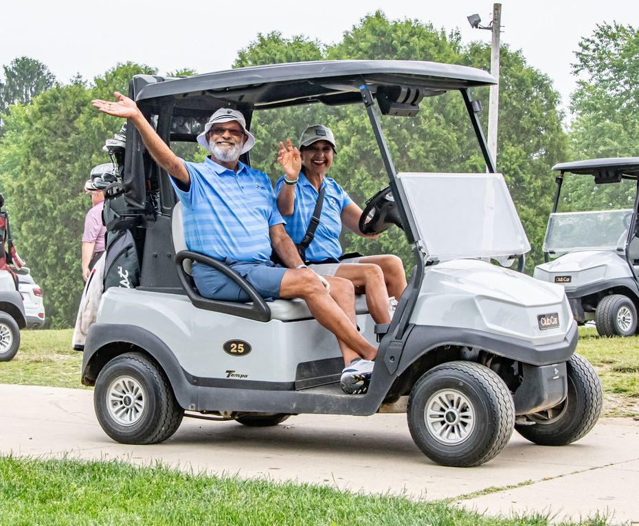 Four men are posing for a picture on a golf course