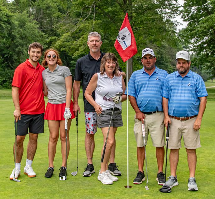 A group of men are posing for a picture on a golf course.