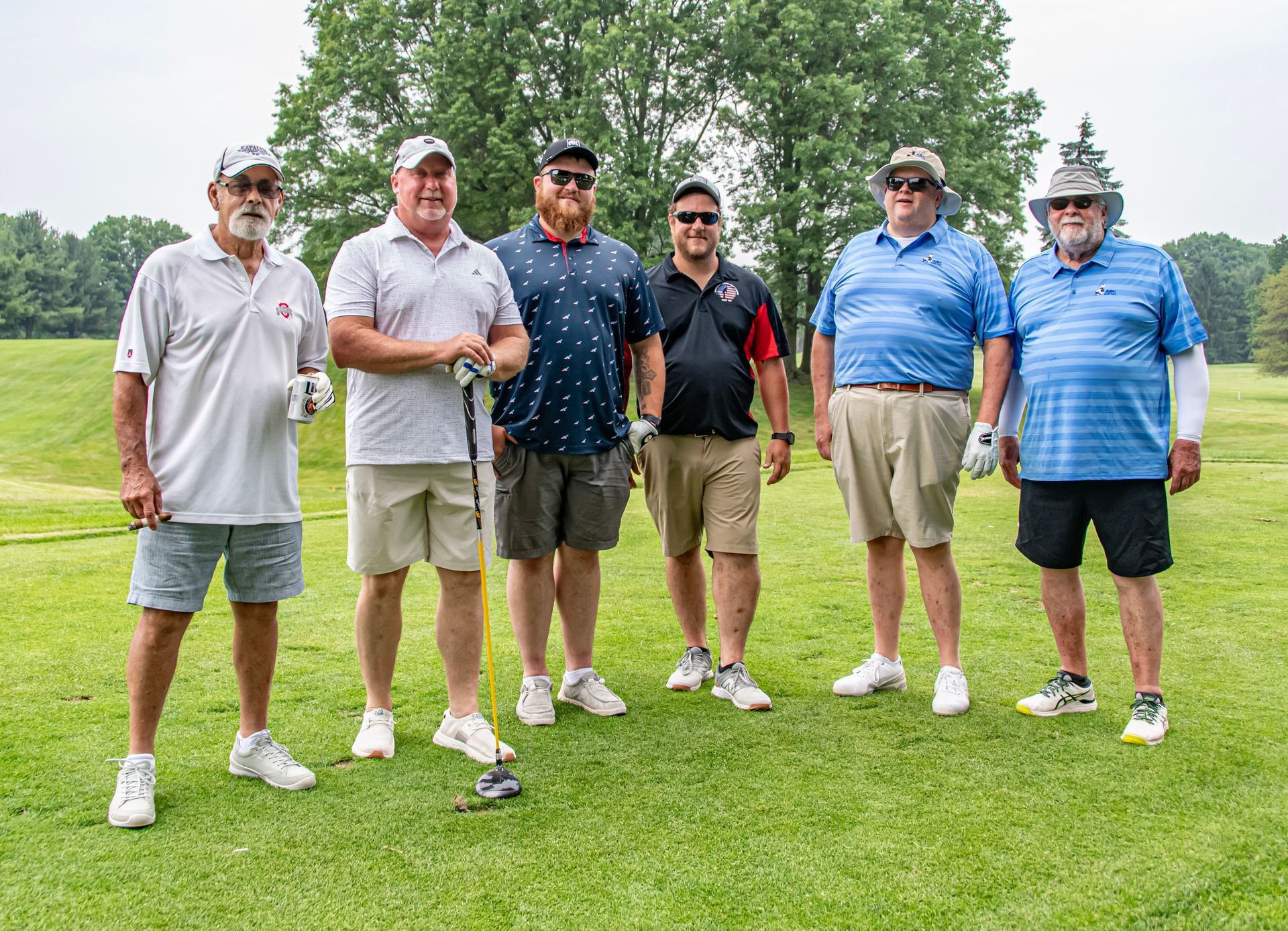 A group of men are posing for a picture on a golf course.