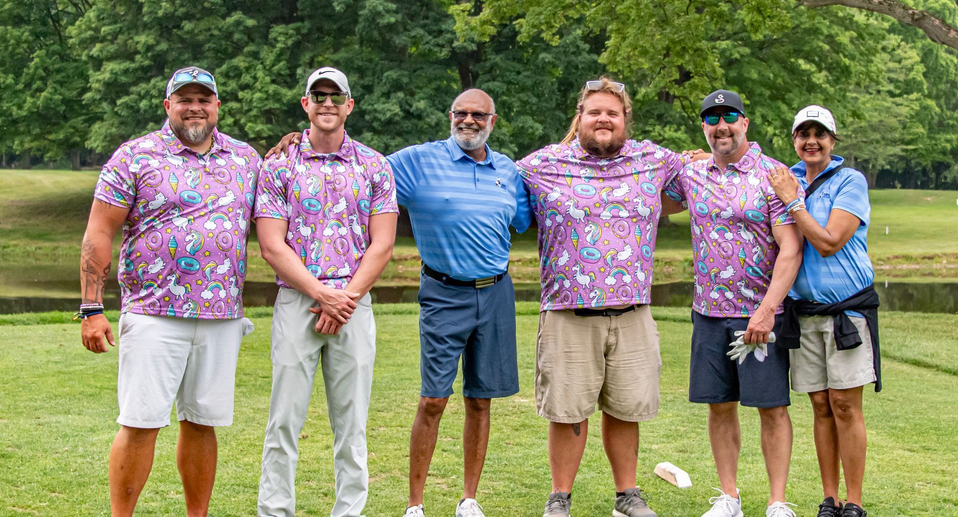 A group of golfers are standing next to each other on a golf course.
