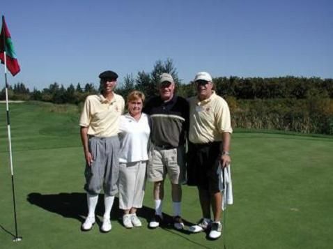 A group of people posing for a picture on a golf course