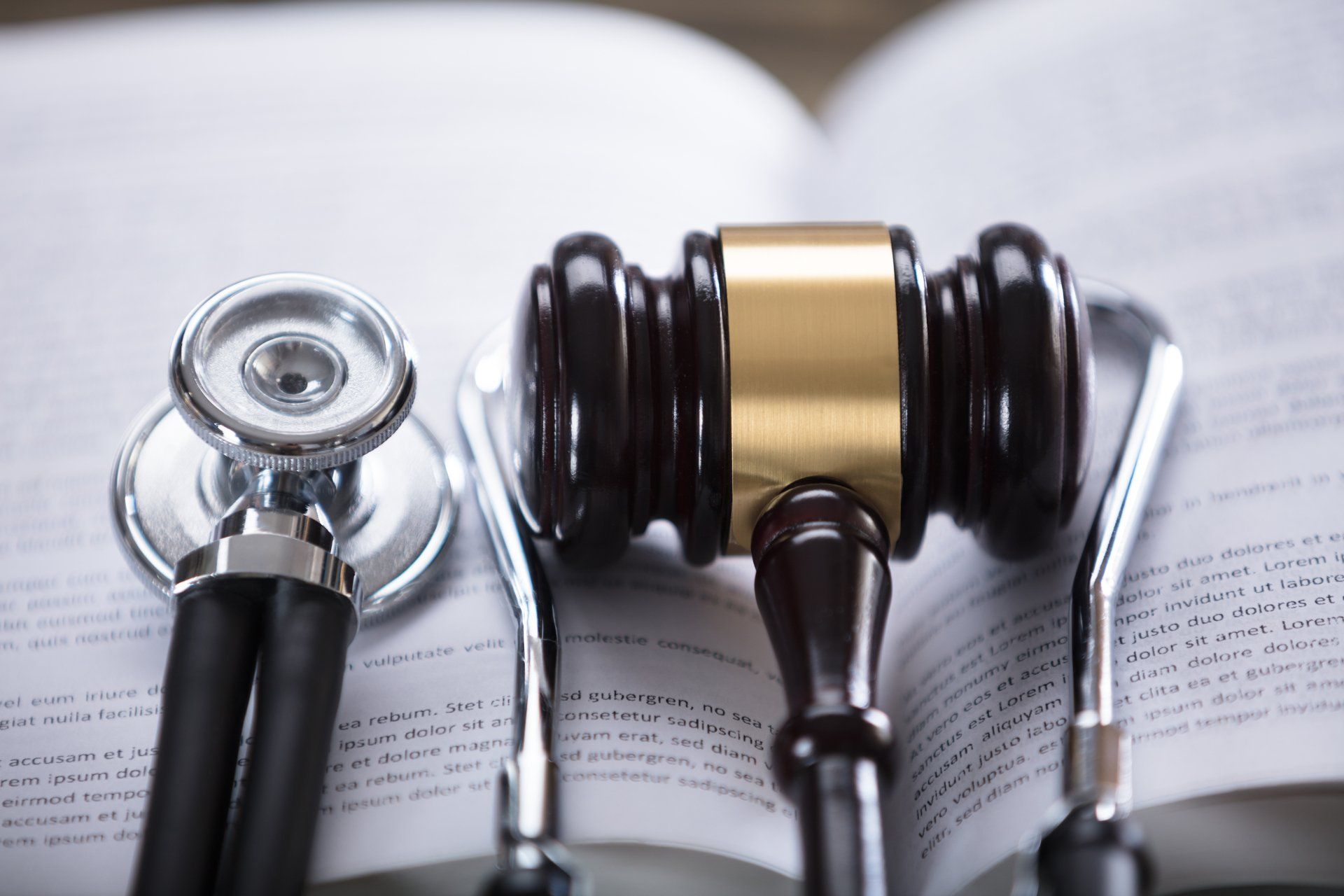 a stethoscope and a judge 's gavel sit on top of an open book