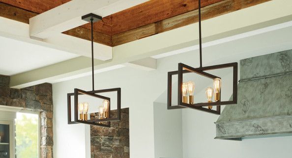 Two modern black geometric pendant lights hanging in a kitchen with rustic wooden beams.