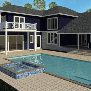 House with pool and jacuzzi. Blue and gray exterior, patio, balcony. Sunny day.
