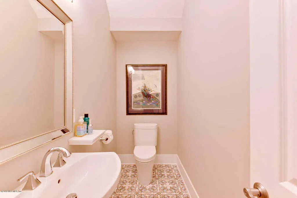 Modern bathroom with double sink vanity, large mirror, and wood-look tile.