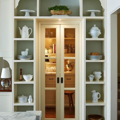 Built-in kitchen storage with open shelving, a pantry, and white dishes.